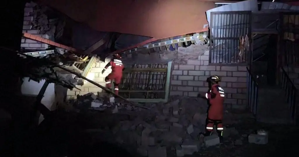 Rescuers searching earthquake damage, as identified in the CBS report; no staged or generated disaster scene.
